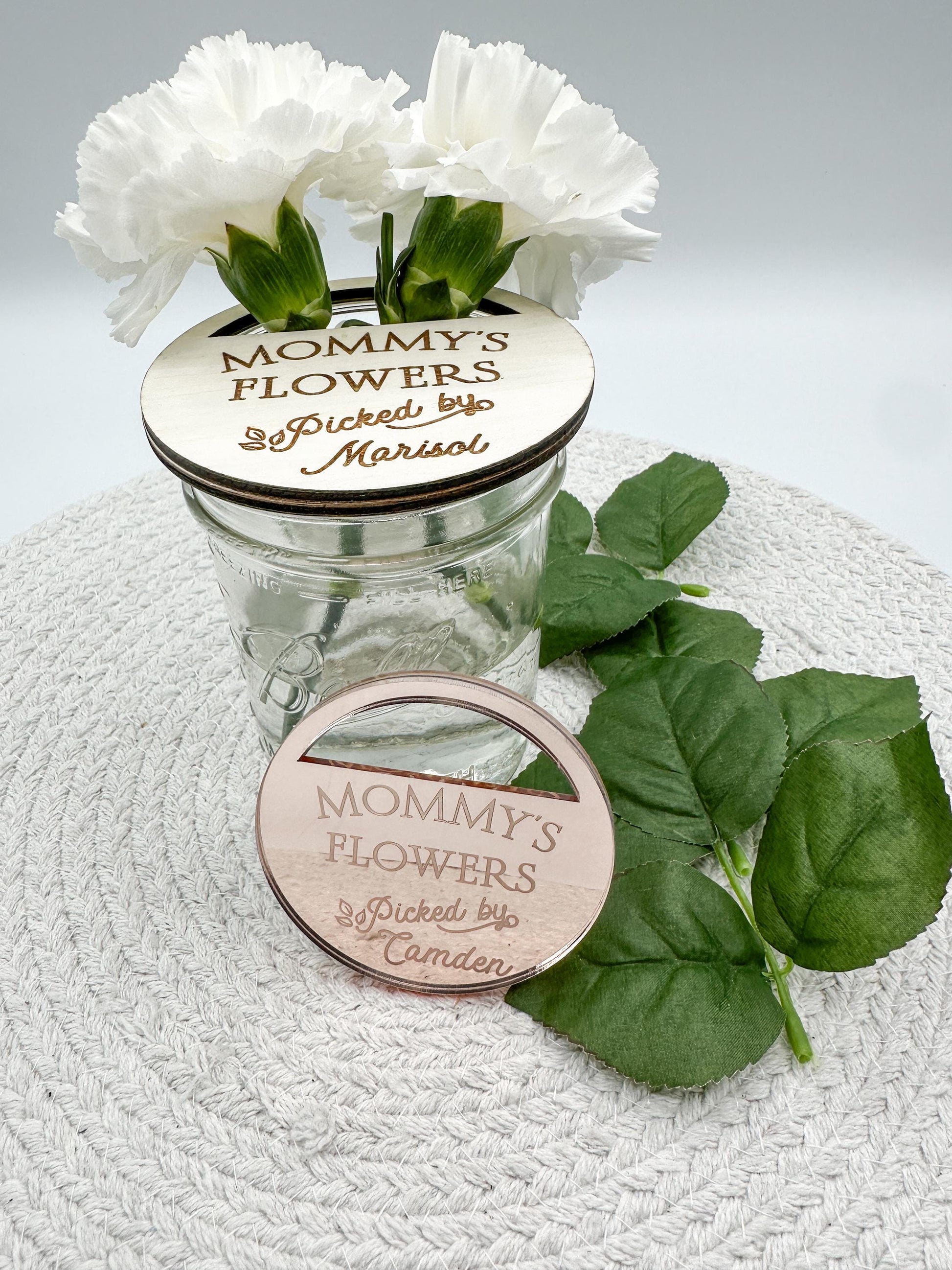 Mother&#39;s Day Mason Jar Lid Flower Holder| Flowers for Mommy| Flowers for Grandma| Mason Jar Lid| Kids Pick Flowers|Mother&#39;s Day Gift|Flowers

Two round wooden signs with a cut-out for flowers. The signs are engraved with the text &#39;Mommy&#39;s Flowers&#39; and &#39;Picked by&#39; followed by a name. The first sign has the name &#39;Marisol&#39; and the second sign has the name &#39;Camden&#39;.