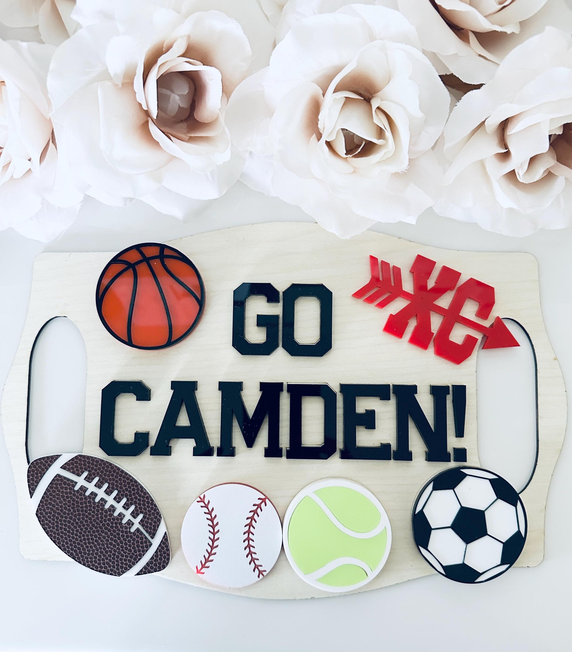 Custom “Go Camden” interchangeable sports sign made of layered wood and acrylic featuring basketball, football, baseball, tennis, soccer, and cross-country icons. Personalized team spirit wall decor for kids, athletes, or sports moms — perfect handmade gift for game day or sports room display.